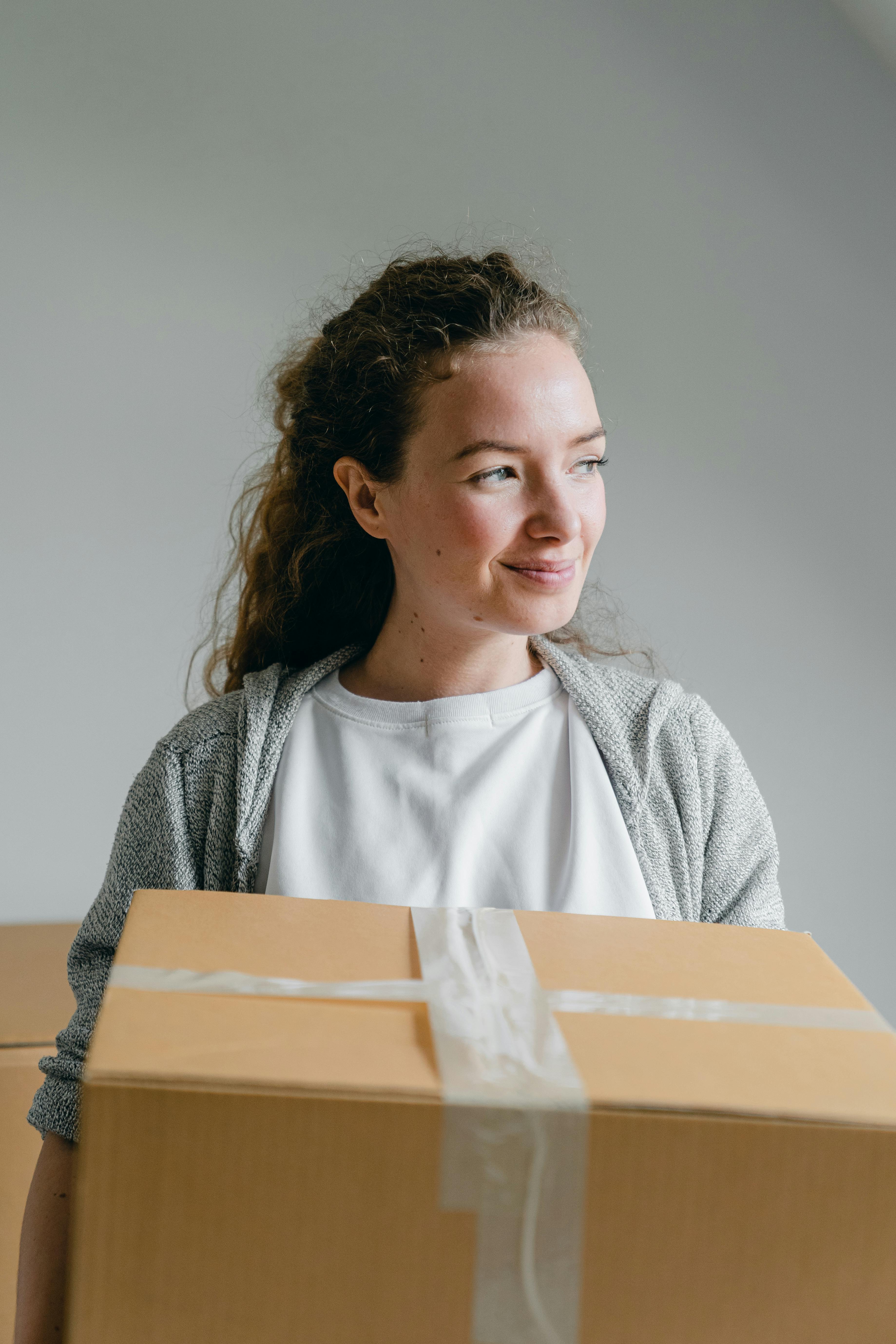 A woman carrying a box | Source: Pexels