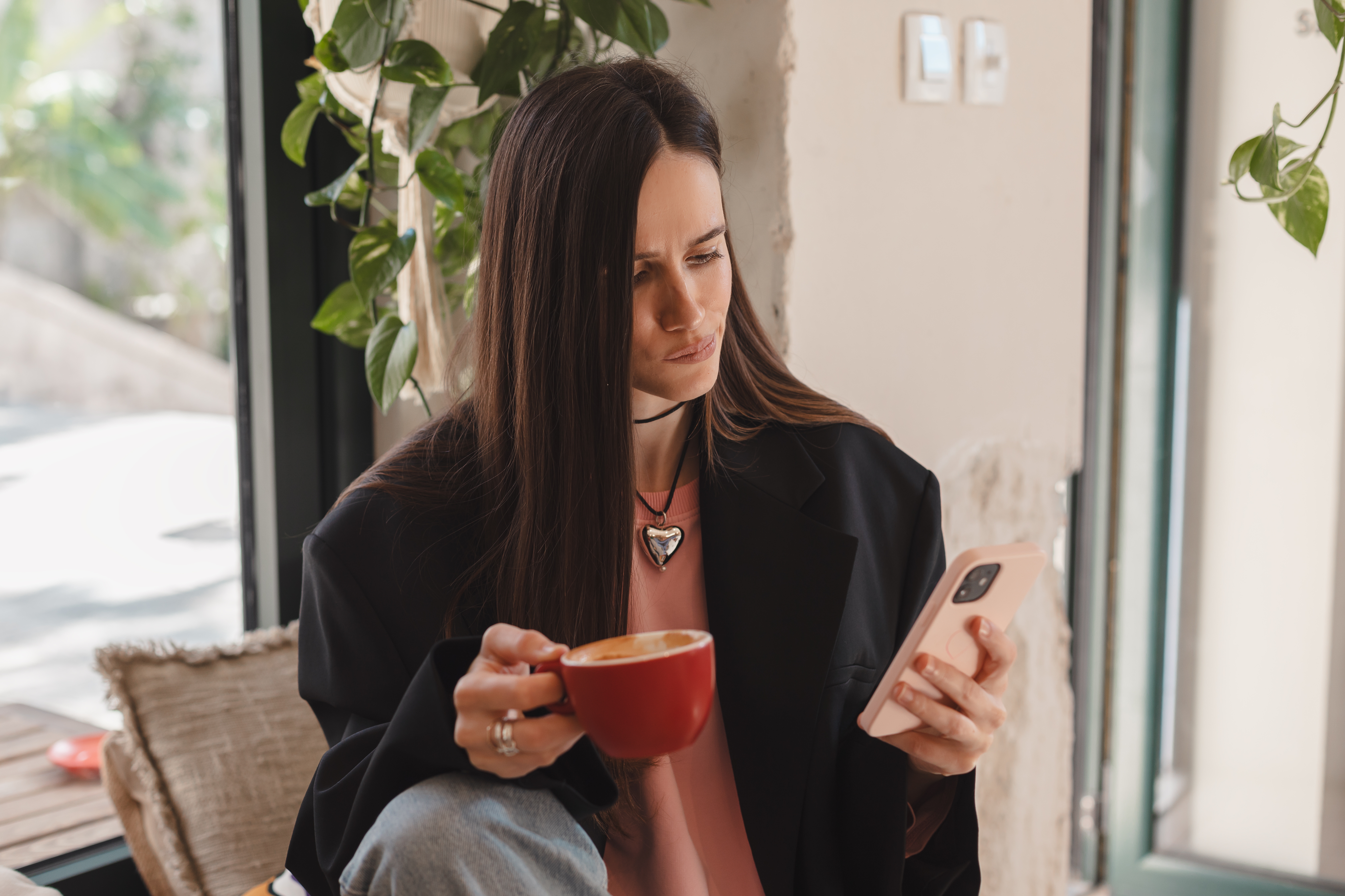 A young woman looking unhappy while checking something on her phone | Source: Shutterstock