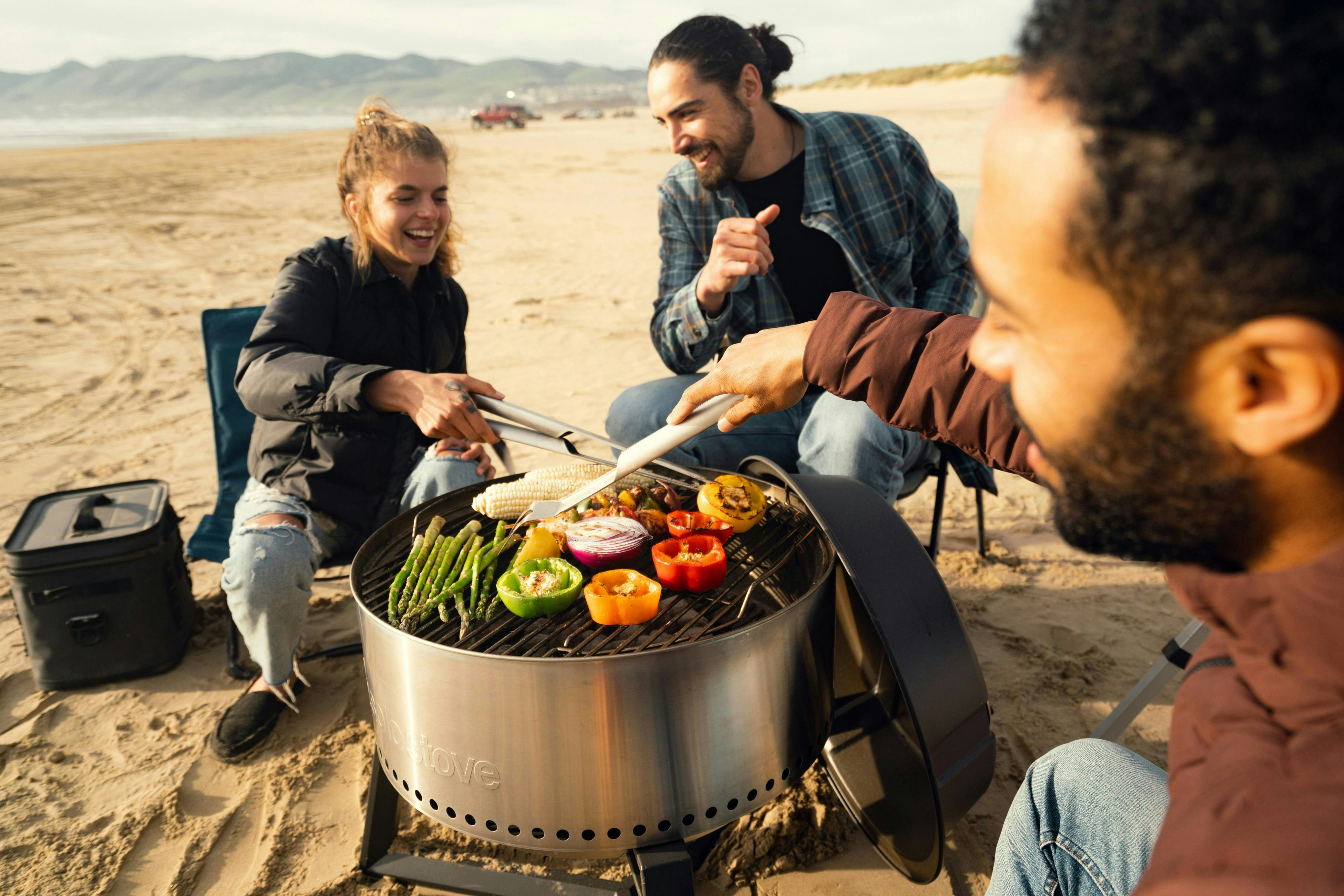 Two men and a woman having fun hanging out at the beach | Source: Pexels