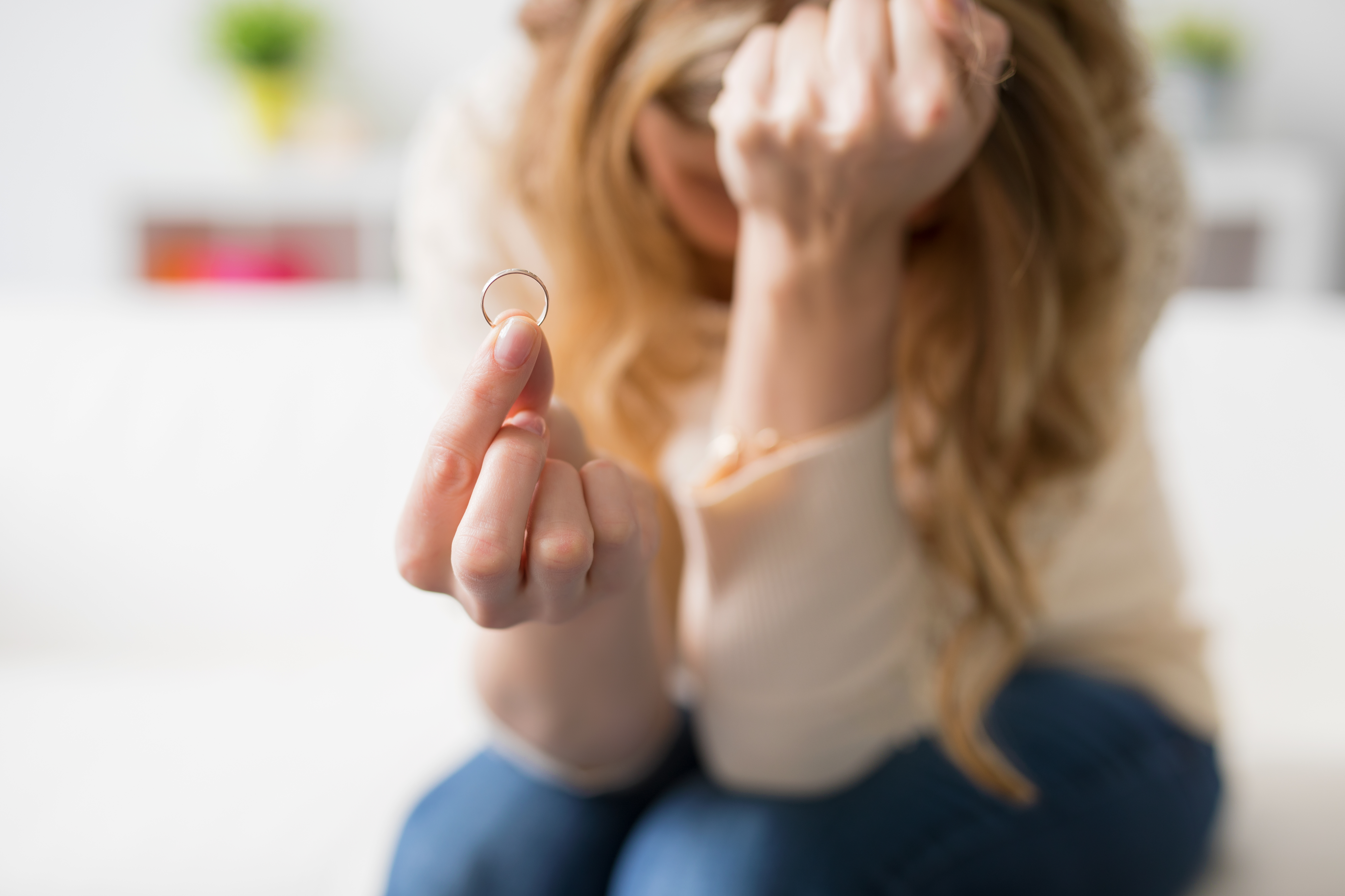 Woman holding up a wedding ring | Source: Shutterstock