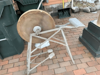 Can anyone identify this? I’m at a holiday cottage, and this is in the garden. It’s mostly metal, has a pedal attached to a large cog with a bolt above it, and looks very old